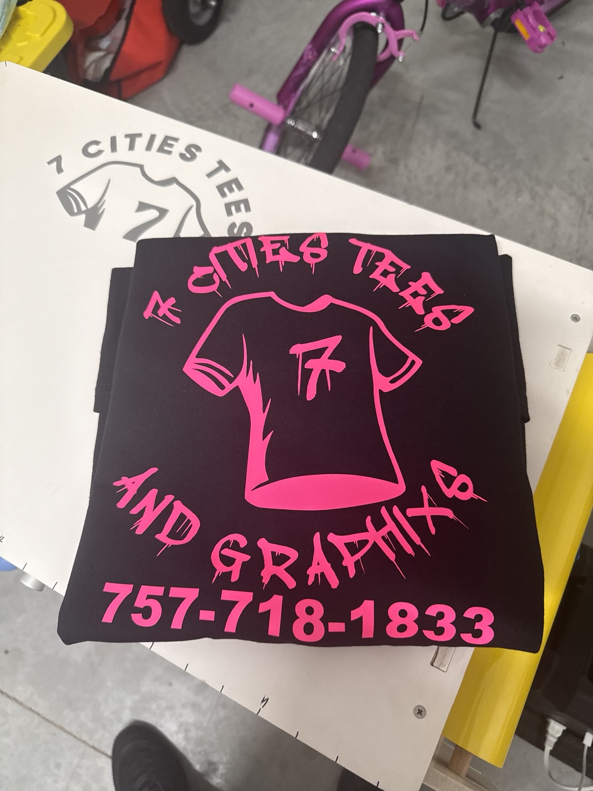 Black 7 Cities Tees and Graphixs shirt with bright pink lettering