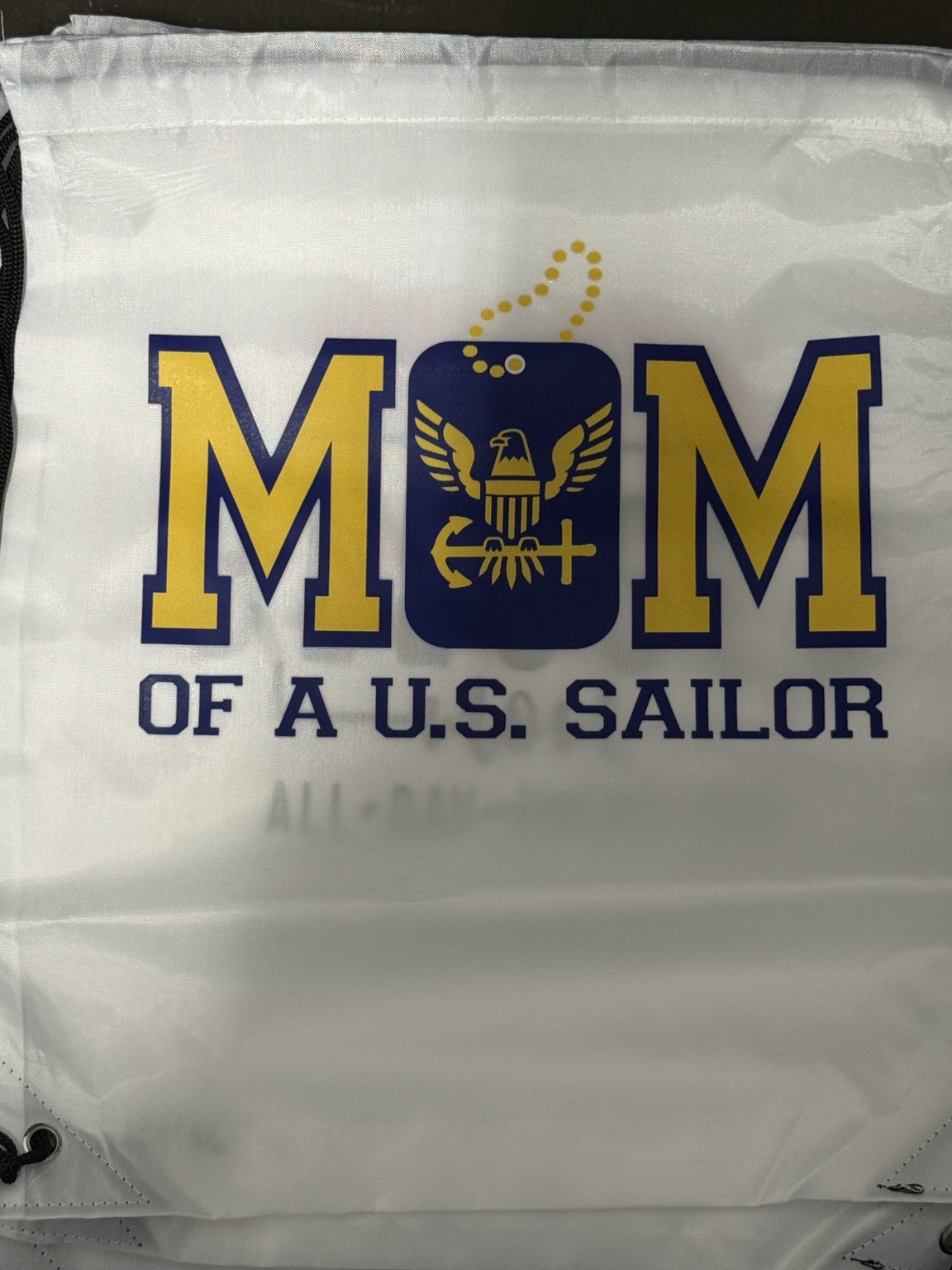 White drawstring bag with a blue and gold Mom of a U.S. Sailor design